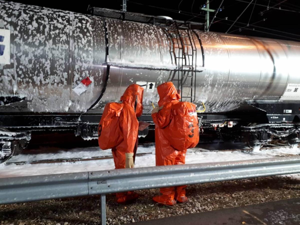 Mensen in gaspak bij treinwagon