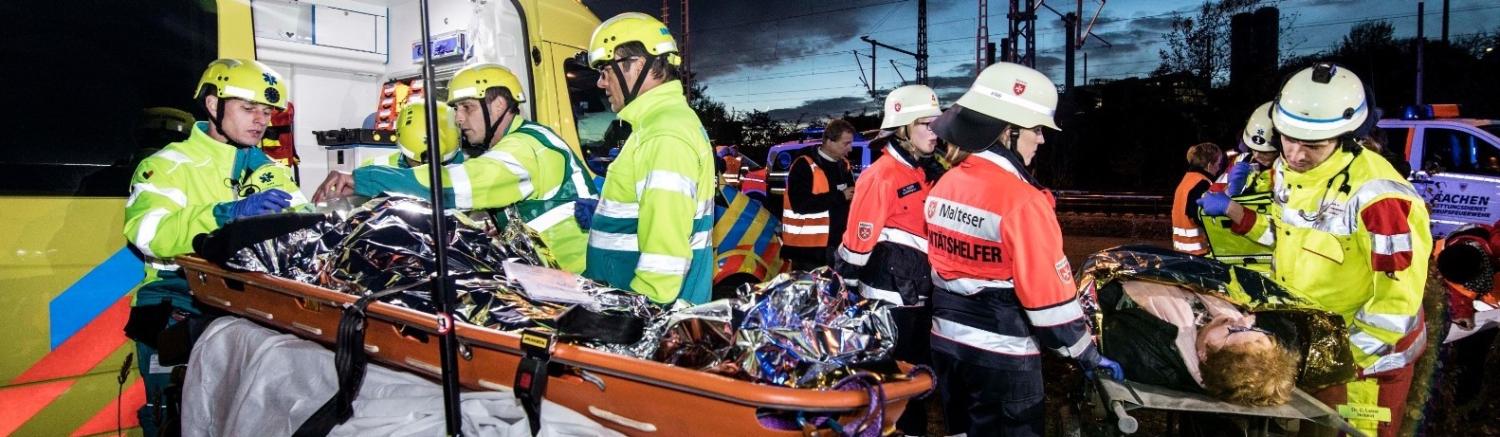 Mensen op brancard en hulpverleners die helpen