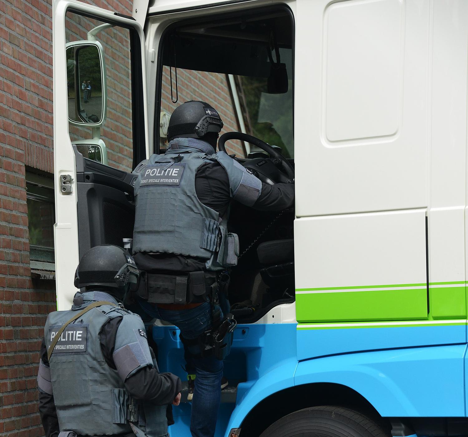De Dienst Speciale Interventies onderzoekt een vrachtwagen die tegen een gebouw is aangereden