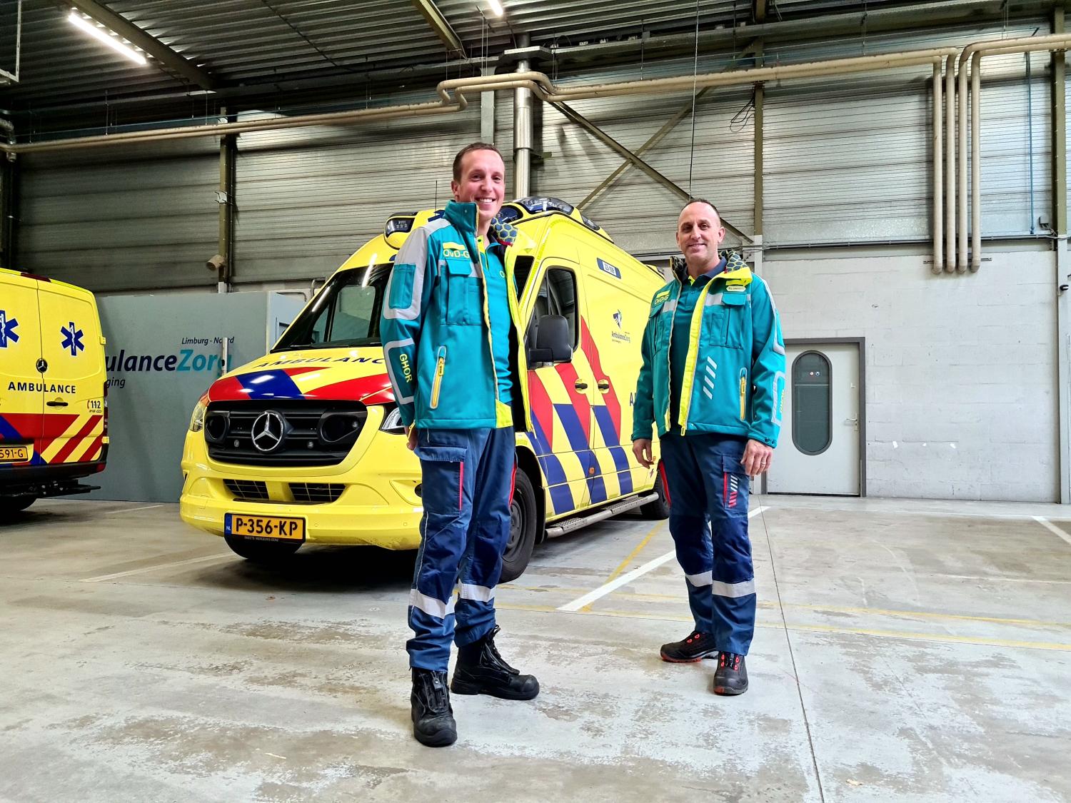 Twee mannen in uniform bij een ambulance