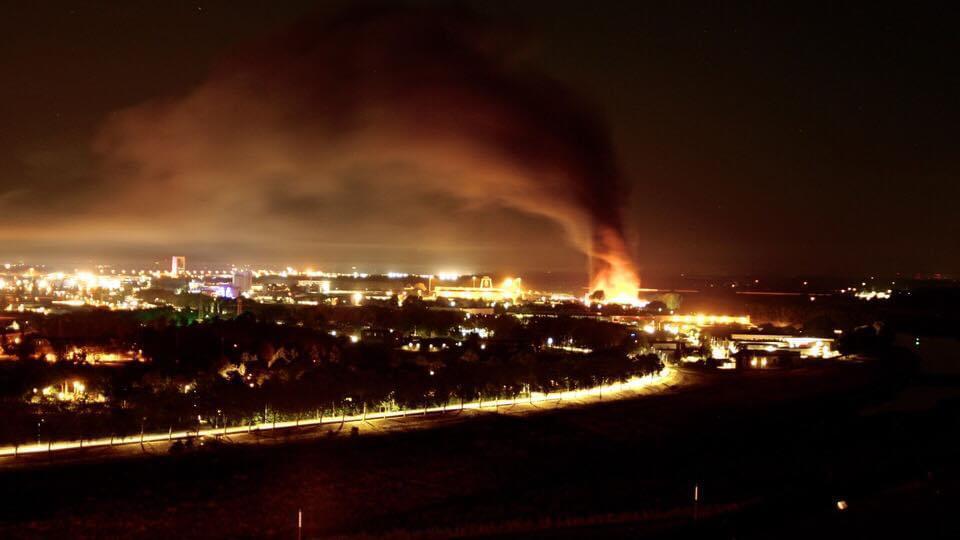 Brand op industrieel terrein met grote donkere wolk