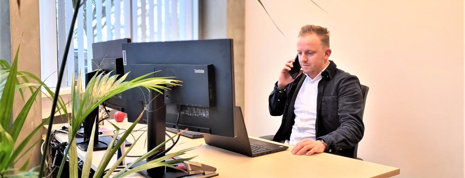 foto van man die aan het bellen is aan zijn bureau