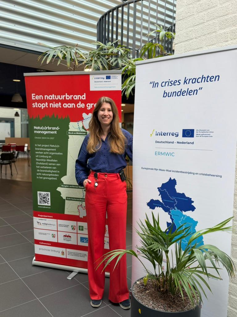 Collega Mara Hoogendoorn bij twee banners 