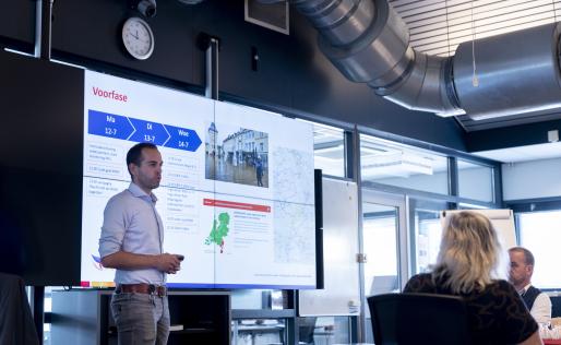 Foto van man die tijdens een vergadering iets vertelt